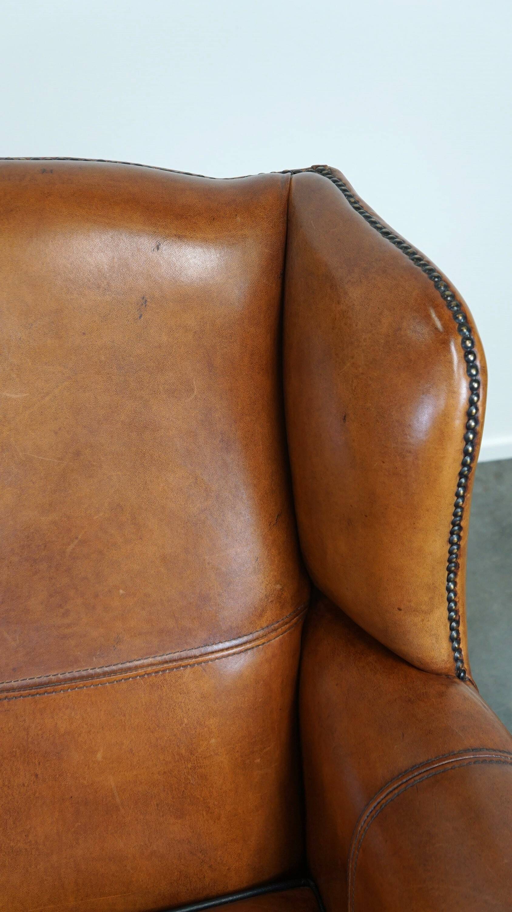 Très beau fauteuil à oreilles en cuir de mouton avec des détails époustouflants