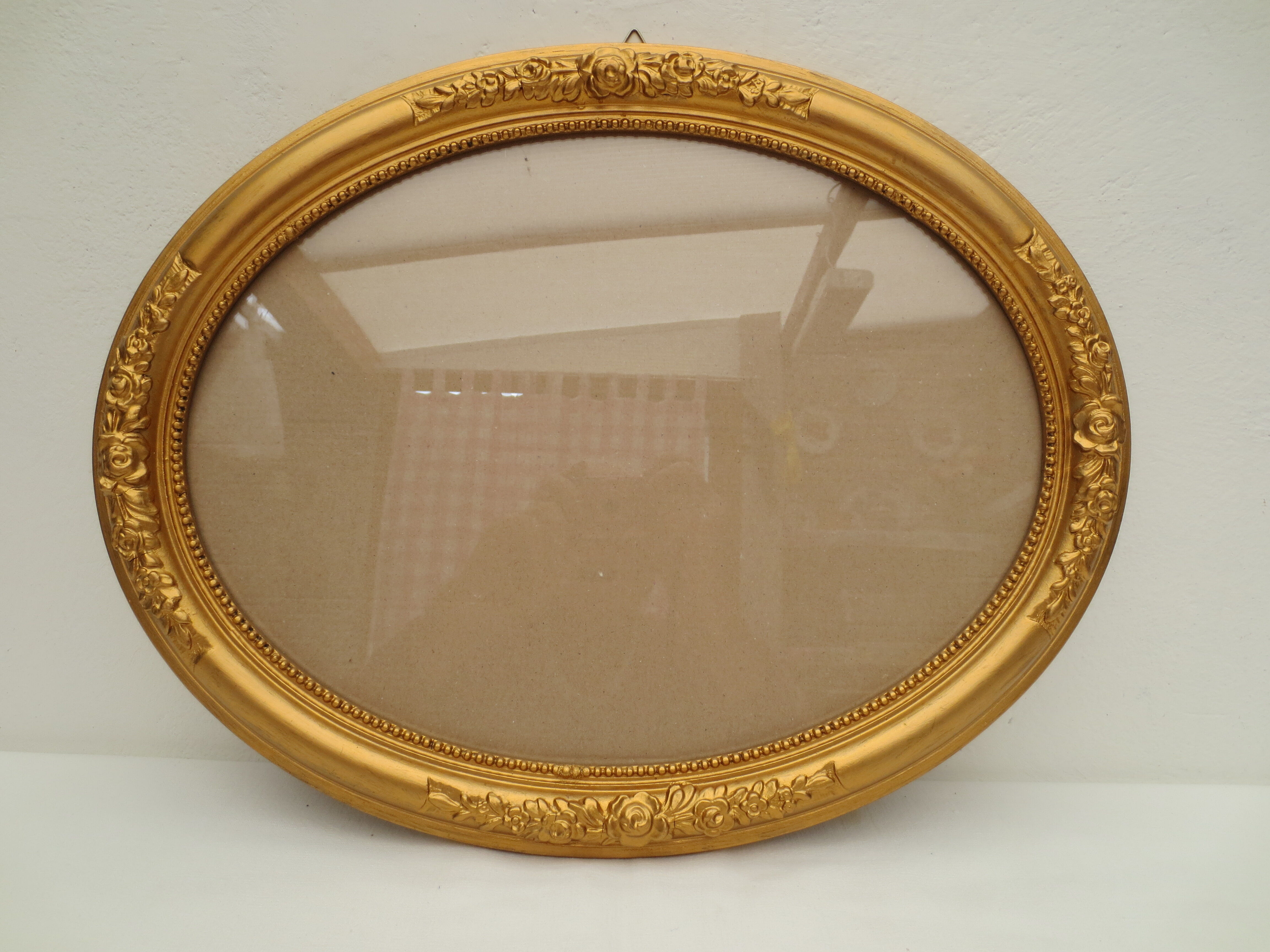 Large old oval gilded wooden frame and stucco decorations