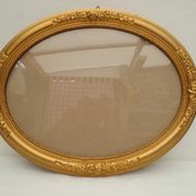 Large old oval gilded wooden frame and stucco decorations