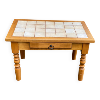 Light solid wood coffee table with tiles and a drawer.