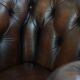 Cowhide English Chesterfield armchair with ball legs and timeless finish