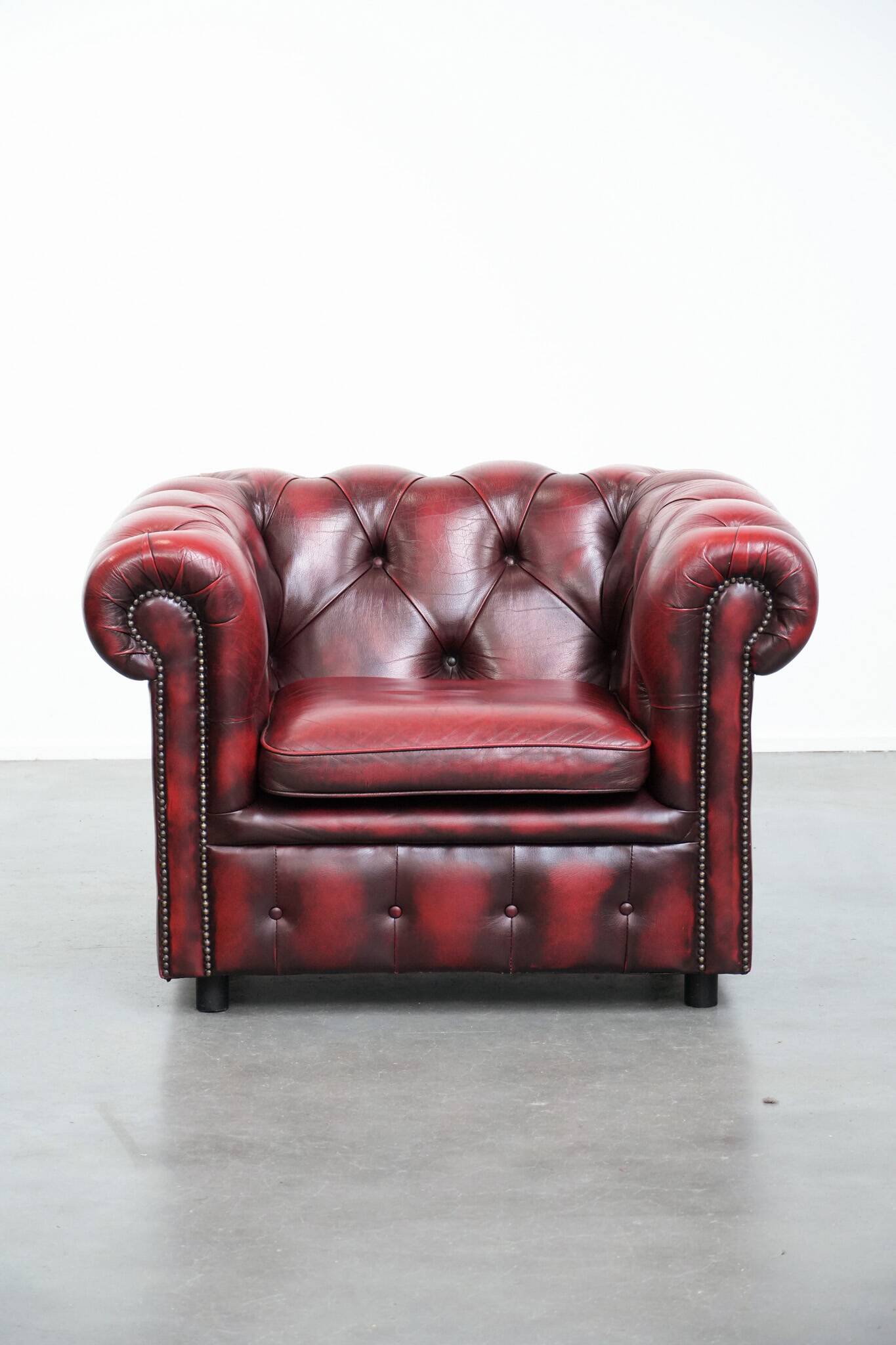 Red English cowhide Chesterfield armchair finished with decorative nails