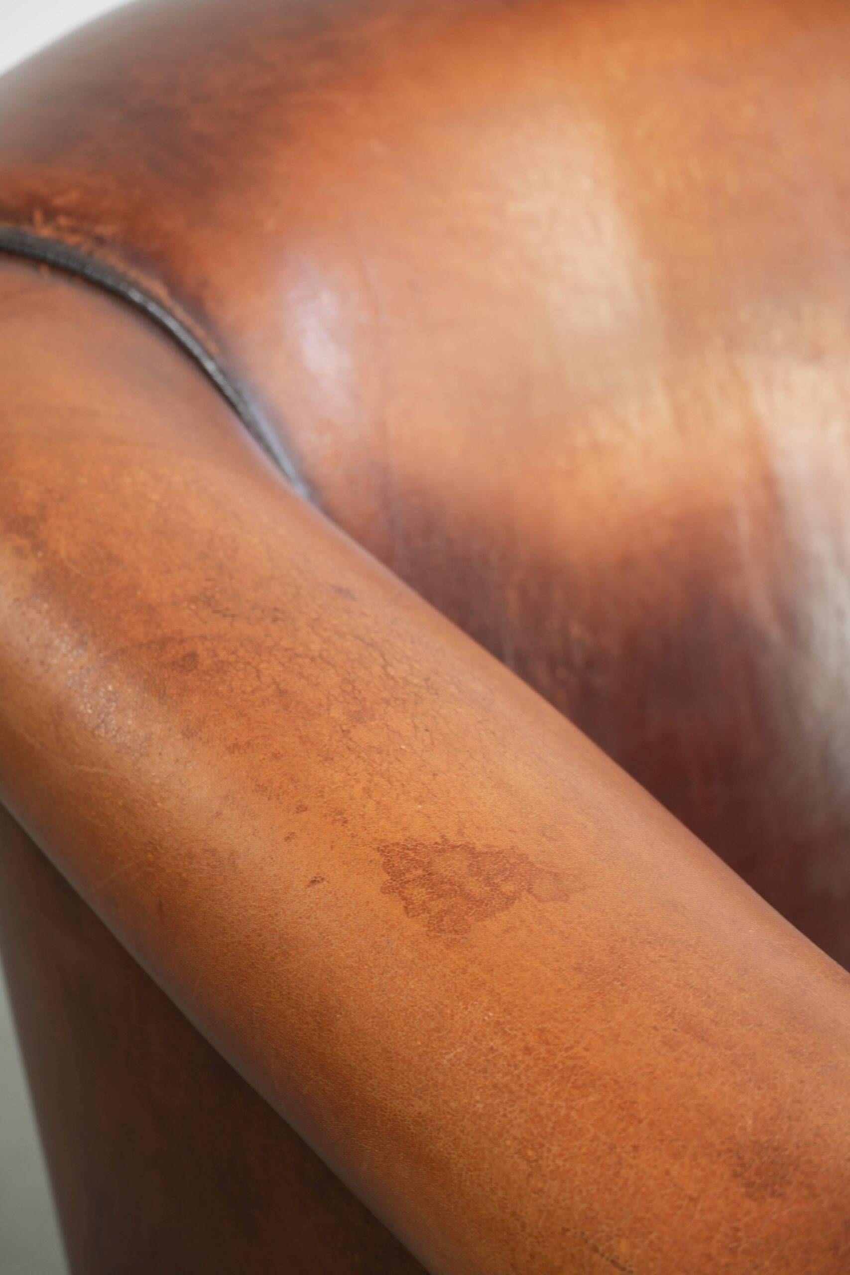 Vintage sheepskin club armchair finished with black piping