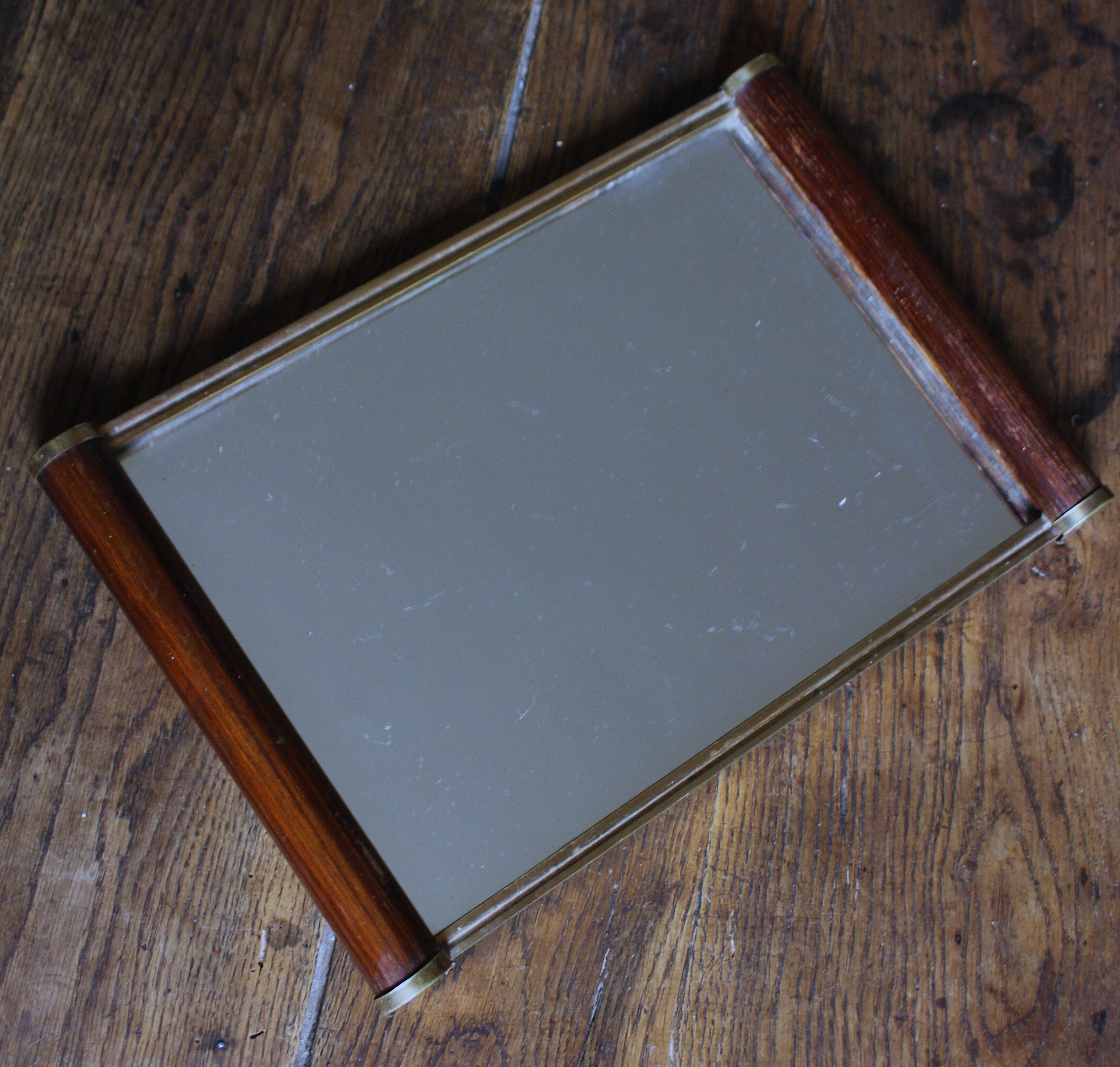 Rectangular mirror tray with wooden handles and gilding.