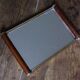 Rectangular mirror tray with wooden handles and gilding.