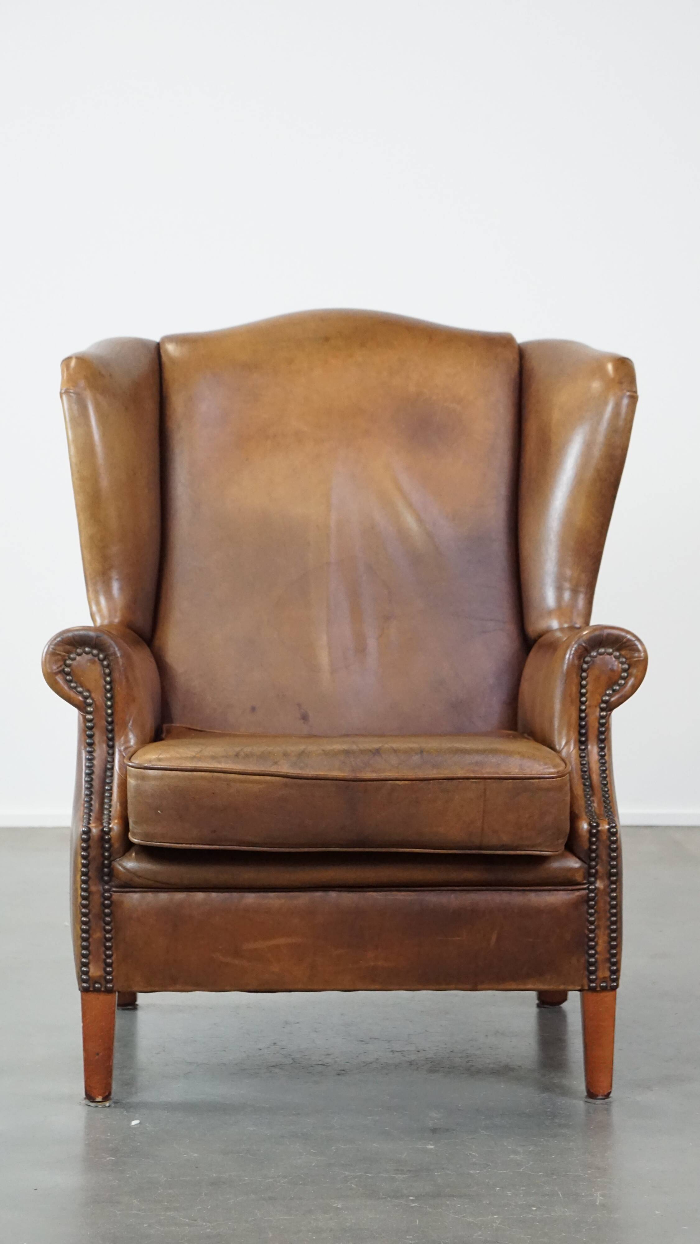 Charming sheep leather wingback armchair with a beautiful patina and excellent seating comfort