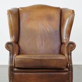 Charming sheep leather wingback armchair with a beautiful patina and excellent seating comfort