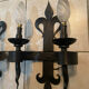 Pair of wrought iron wall lights in fleur-de-lis château style.