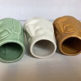 Set of three small Moai-style head vases.