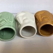 Set of three small Moai-style head vases.