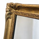 Antique mirror with a gilded frame and foliage decoration.