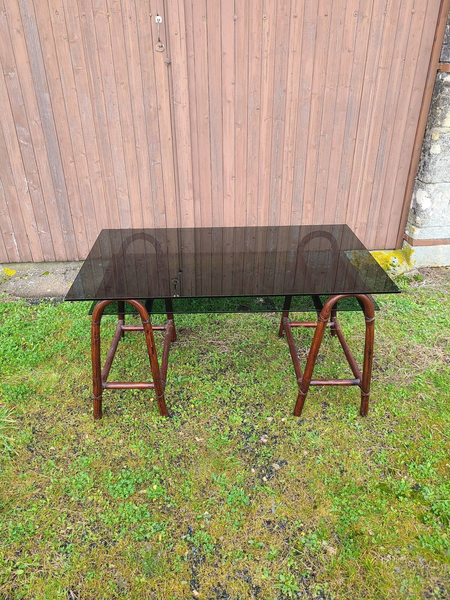 Smoked glass desk on rattan legs and leather detail