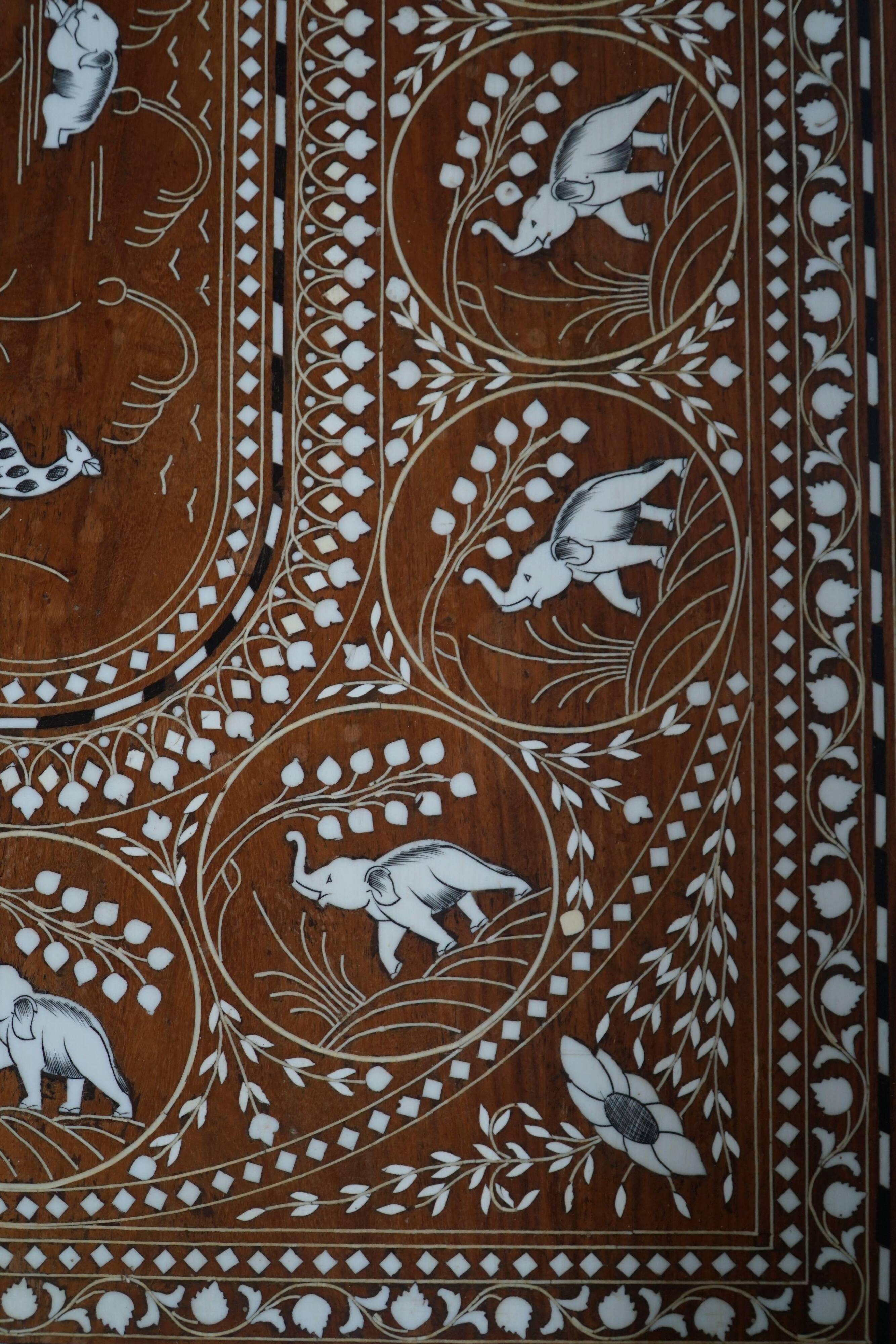 Vintage Indian teak coffee table inlaid with elephant motifs, mid-20th century.