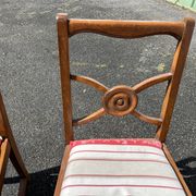 Pair of antique walnut chairs with rose design and red striped cushions.