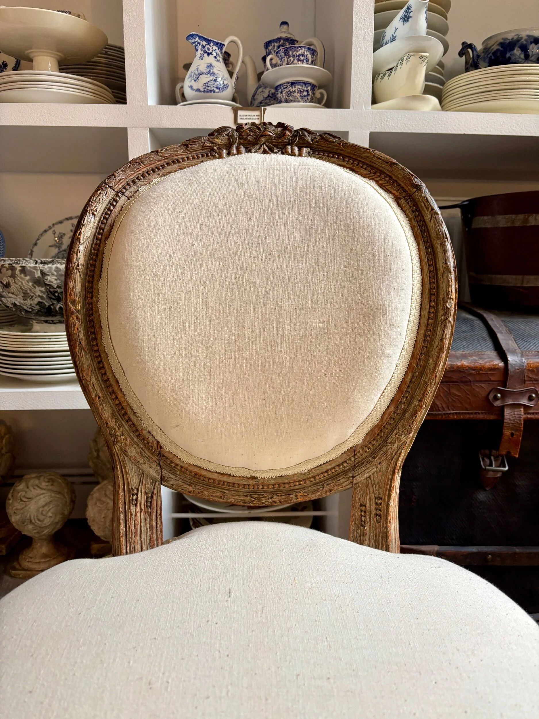 Medallion back chair in moulded wood and beige fabric.