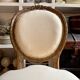 Medallion back chair in moulded wood and beige fabric.