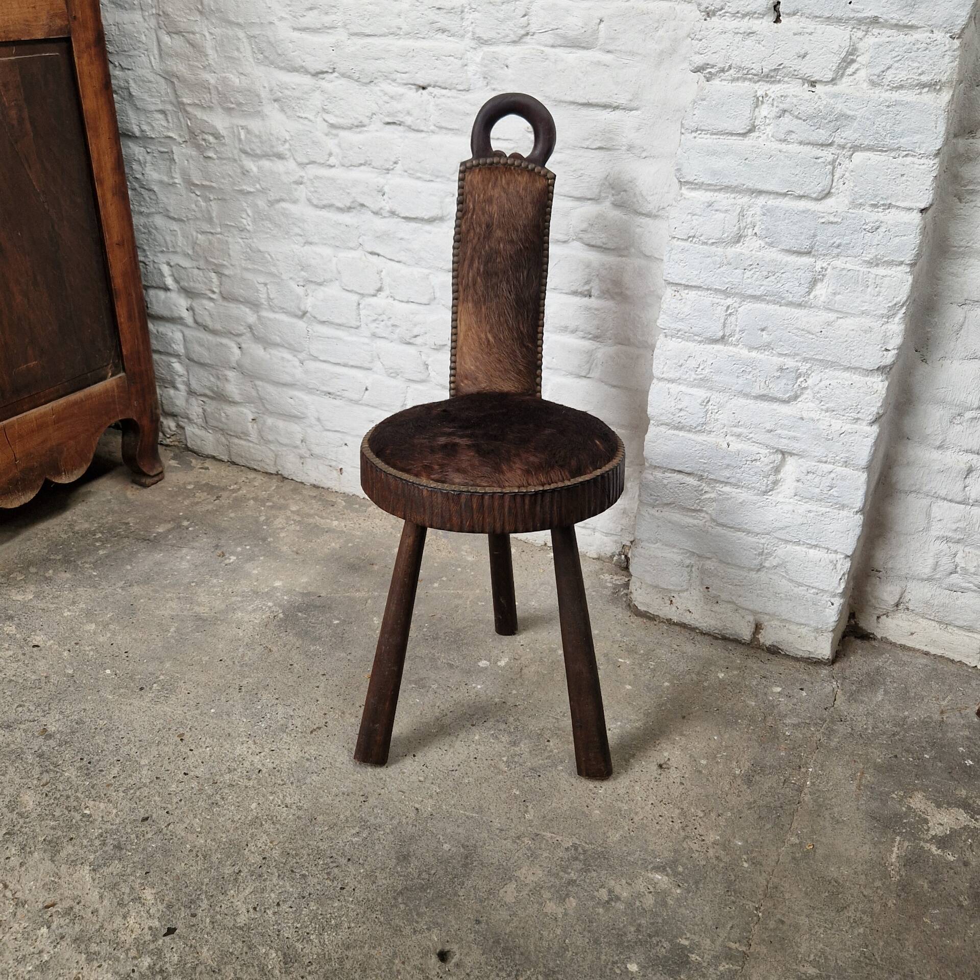 Antique tripod chair in solid wood and animal skin.