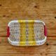 Vintage woven basket in yellow, white, and pink plastic.