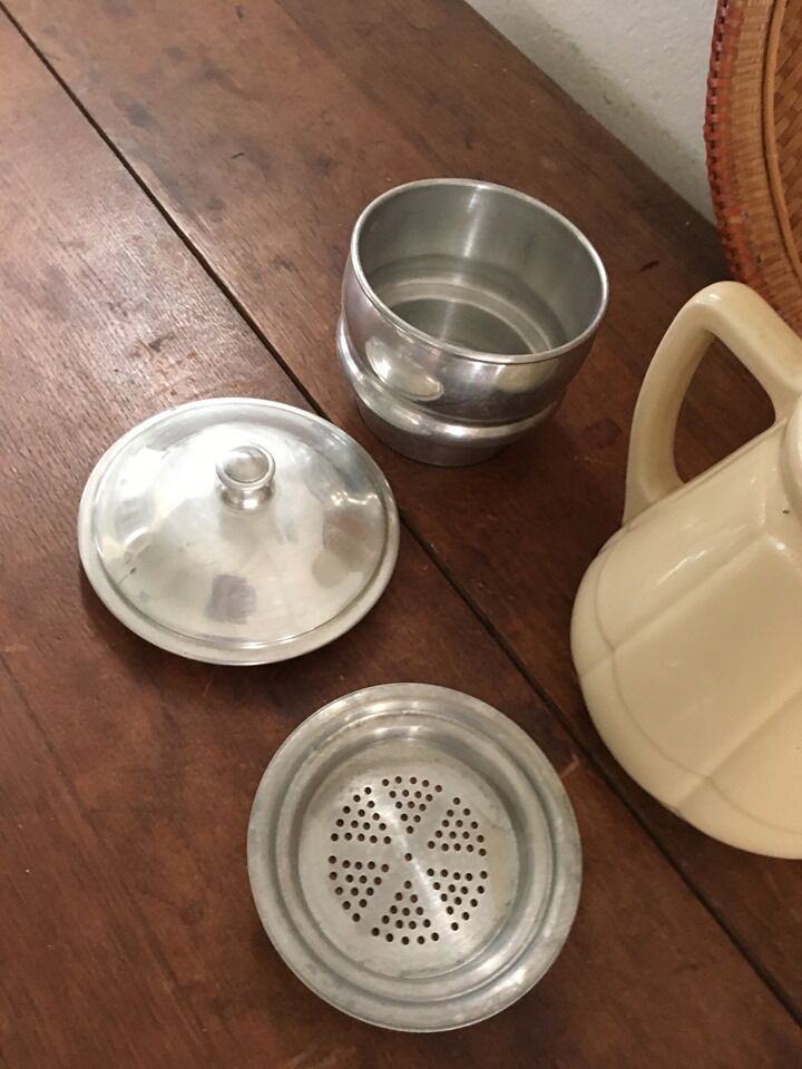 Old tea pot or coffee maker in faience cream with filter.