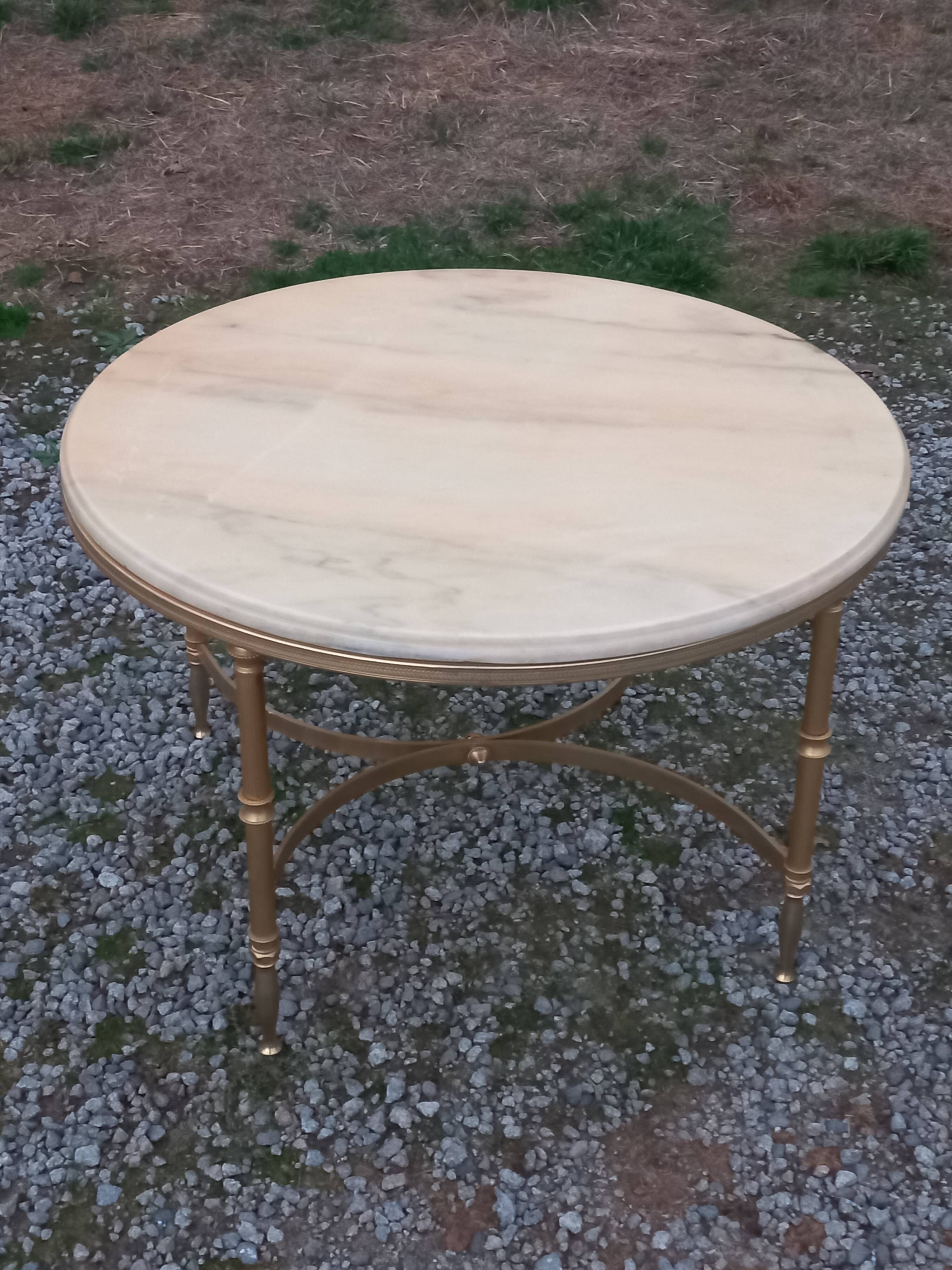 Round neoclassical coffee table with a marble top and golden metal base.