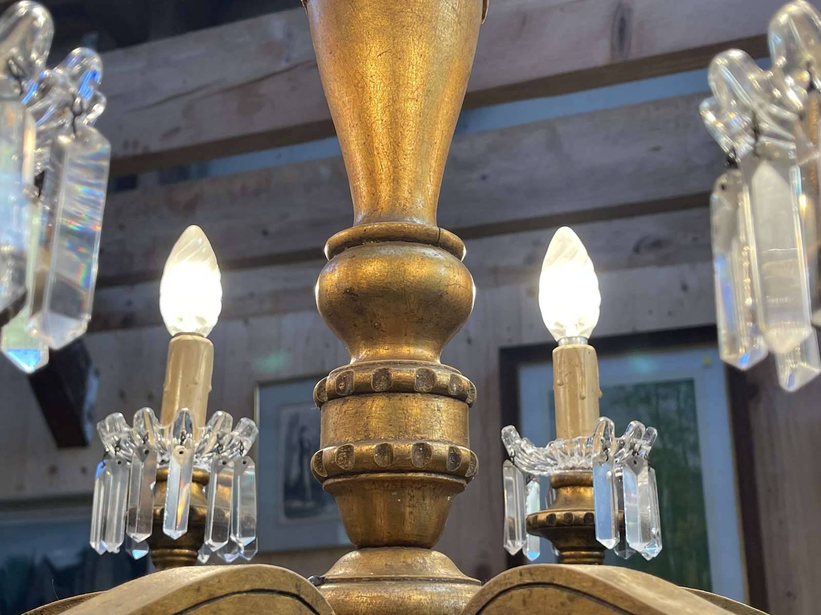 Golden wooden chandelier with crystal pendants from the 19th century.