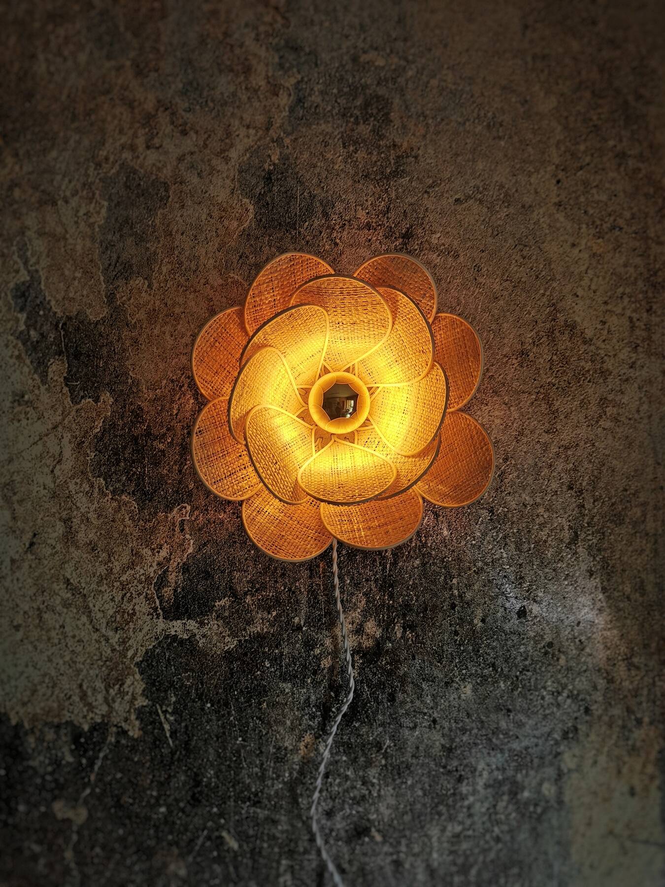 Flower wall light made of rattan and raffia petals