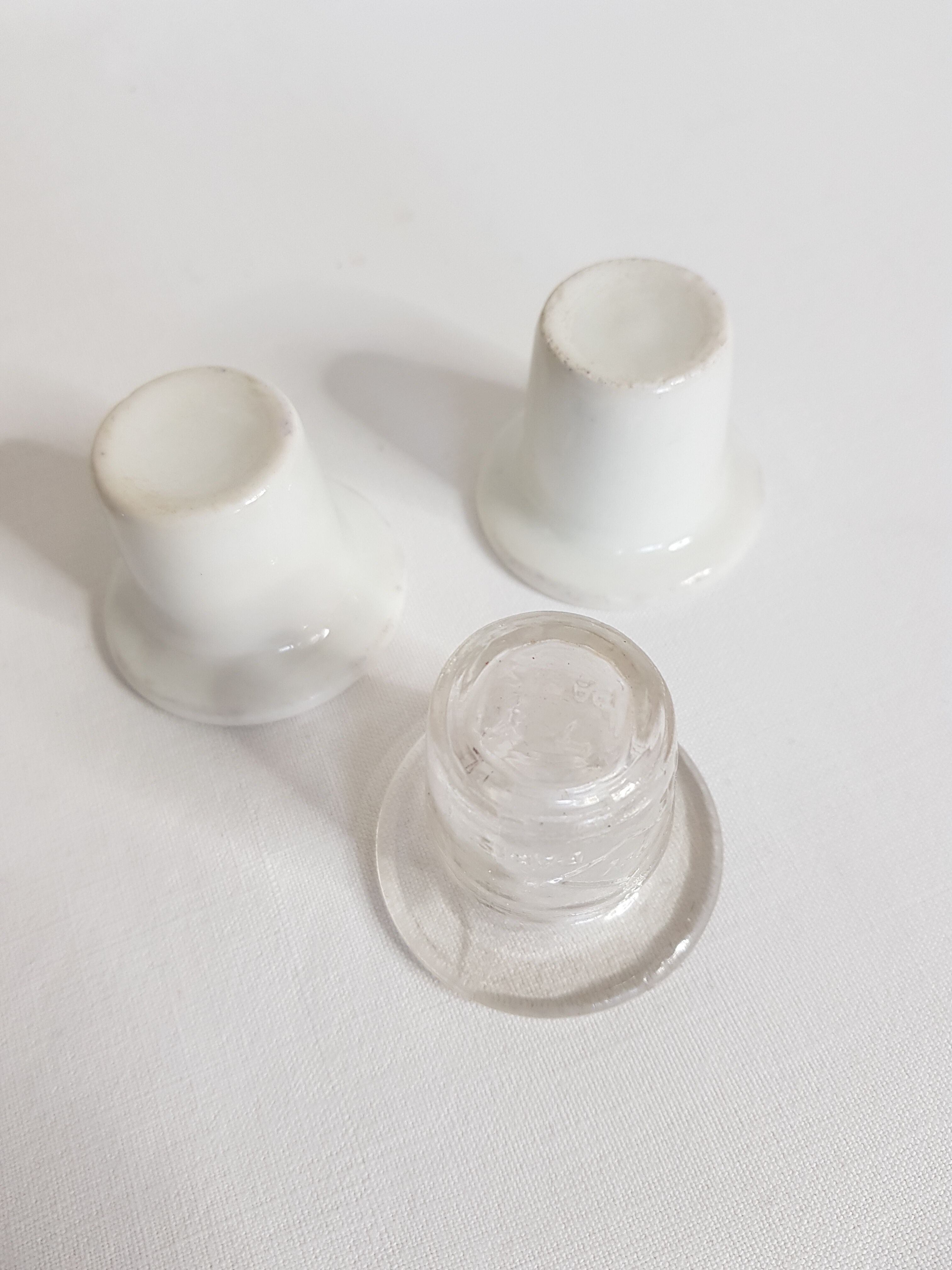 Three white porcelain and glass inkwells for school desk