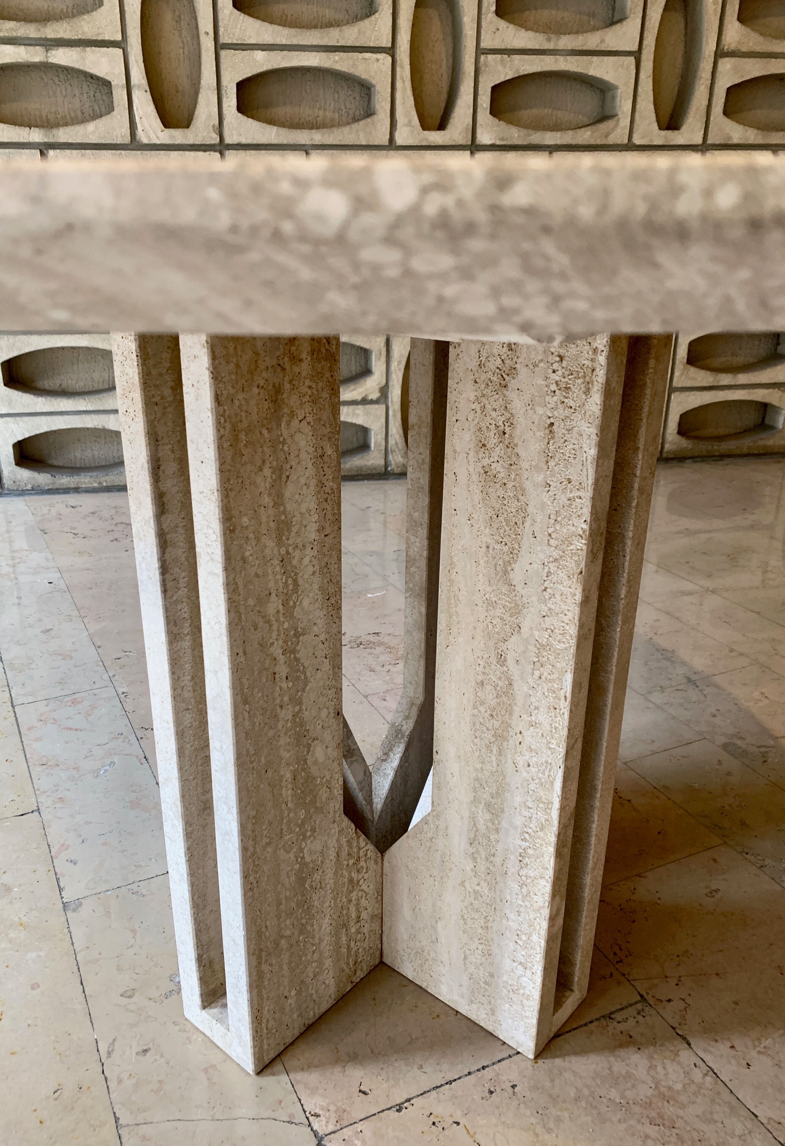 Round travertine dining table with double cross foot