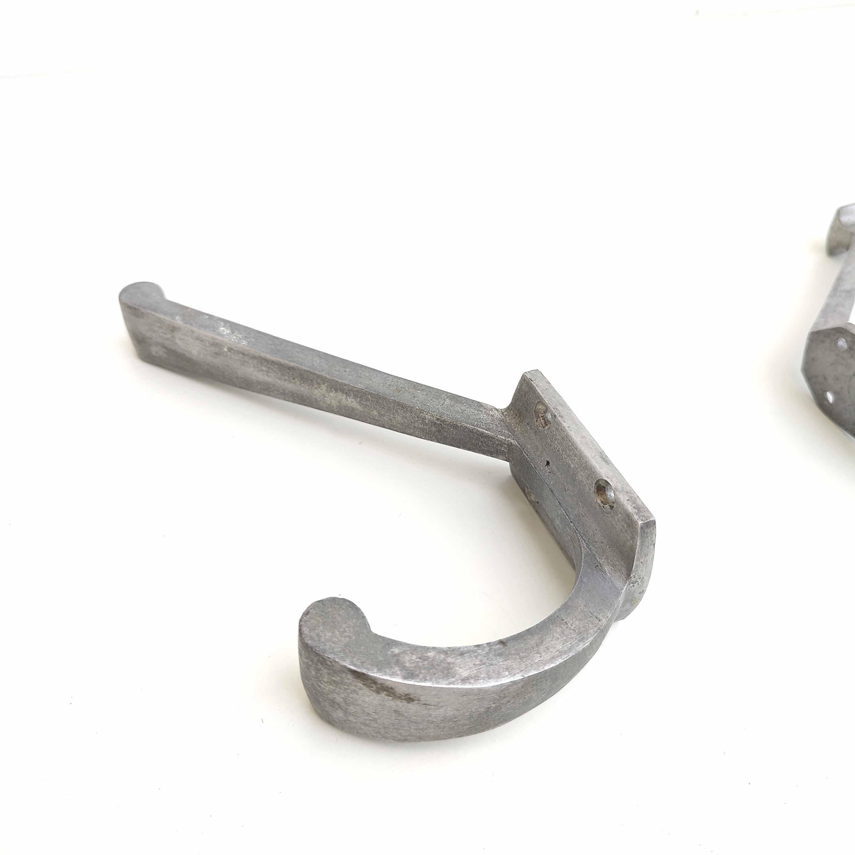 Two mismatched art deco aluminum hooks