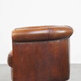 Sheep leather club chair in a cognac color and finished with piping