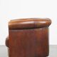 Sheep leather club chair in a cognac color and finished with piping