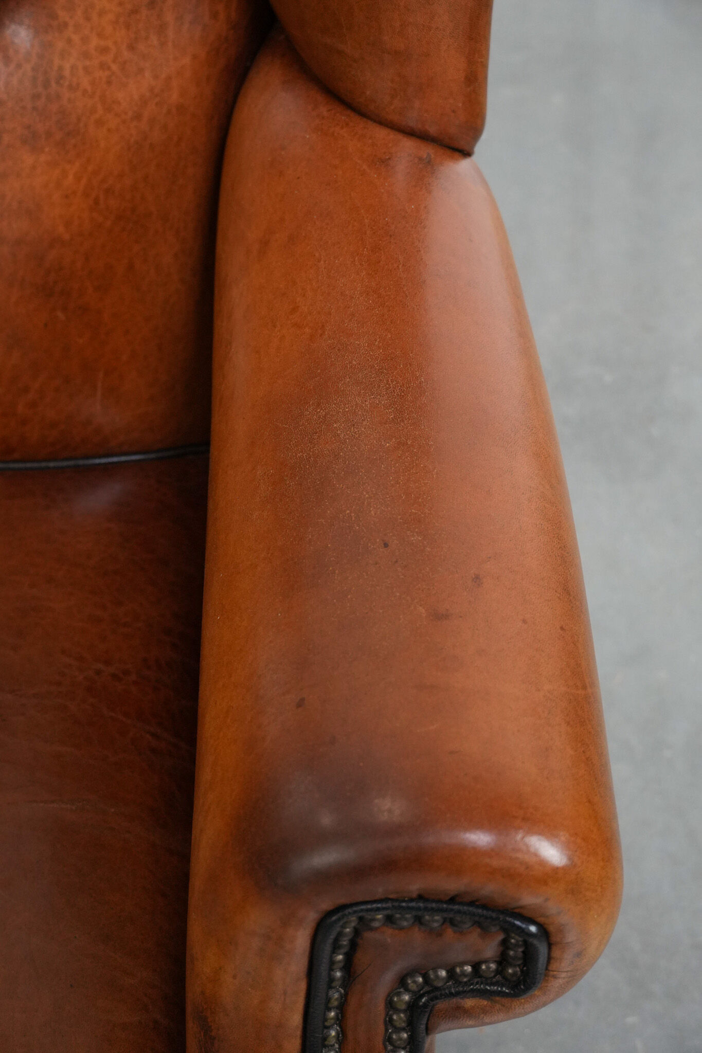Wingback chair made of sheep leather with black piping in good condition