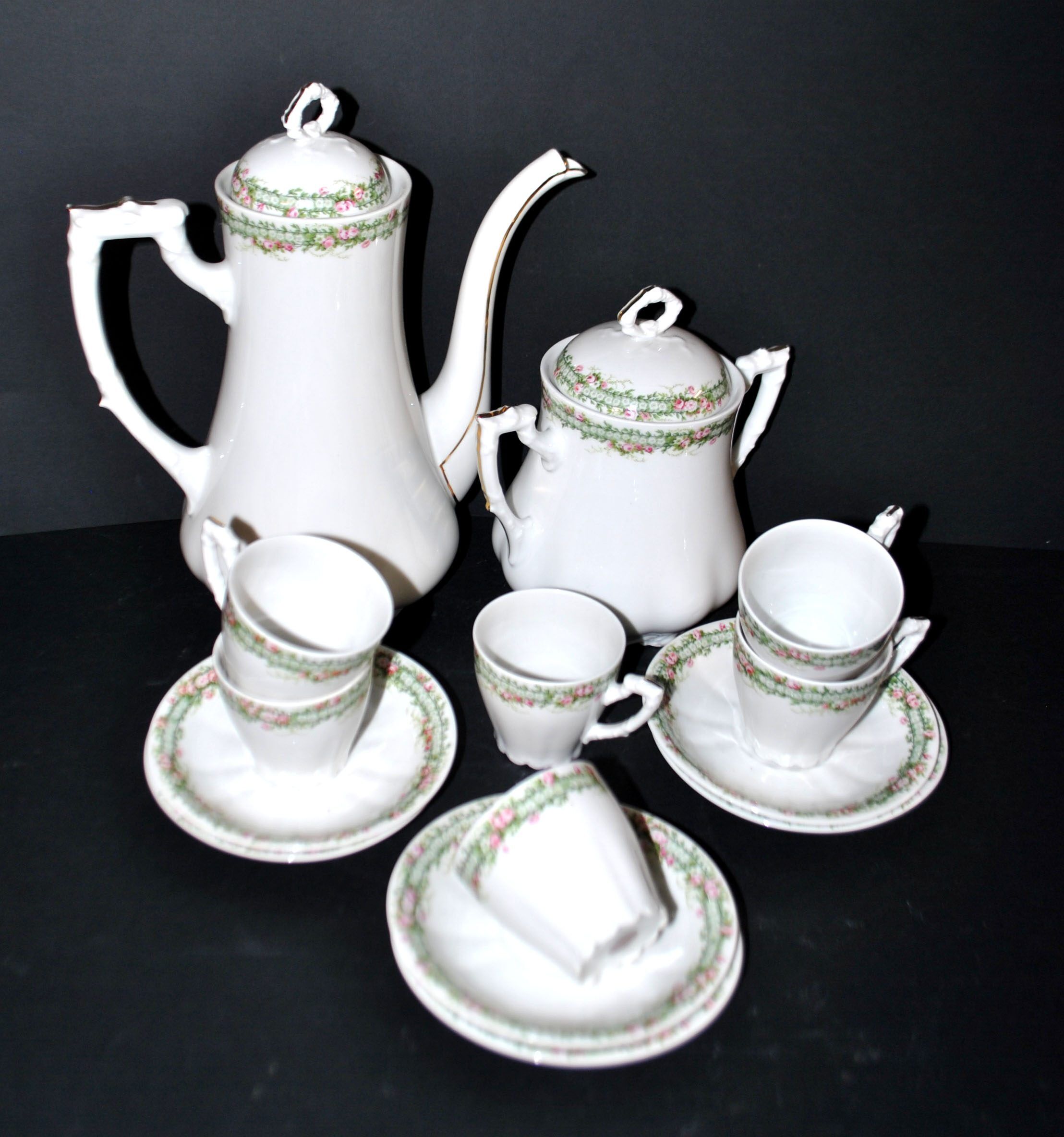 Vintage Limoges coffee service with pink and green floral decoration, coffee pot, sugar bowl, and 6 cups.