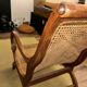 Colonial planter's armchair in solid teak, scroll armrests, caned seat.