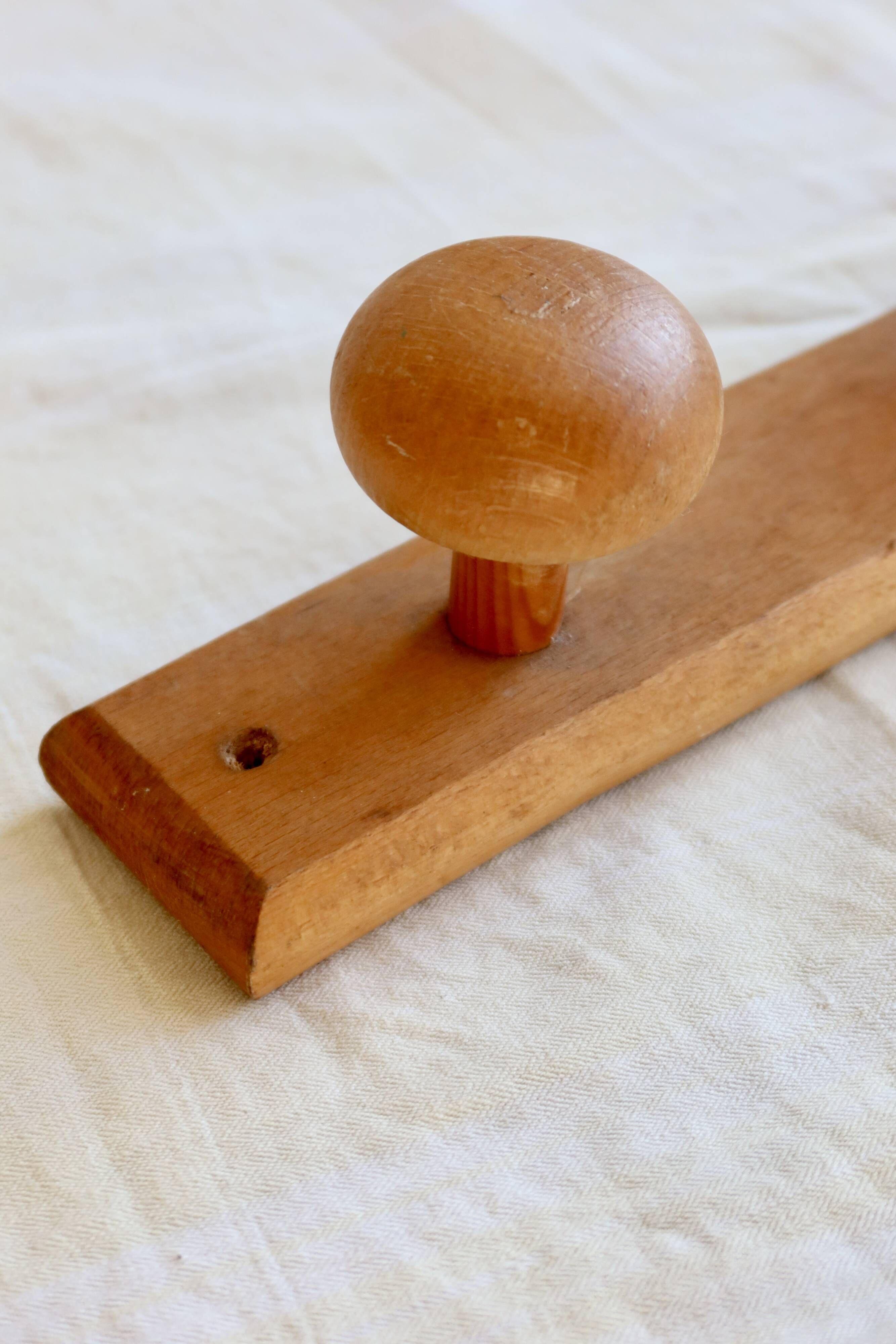 Vintage wooden coat rack with two round hooks.