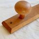 Vintage wooden coat rack with two round hooks.
