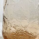 Translucent pinkish iridescent cracked glass bottle.