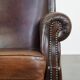 Dark brown sheepskin armchair finished with decorative nails