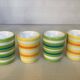 Four striped egg cups in yellow and green.