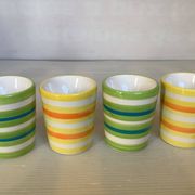 Four striped egg cups in yellow and green.