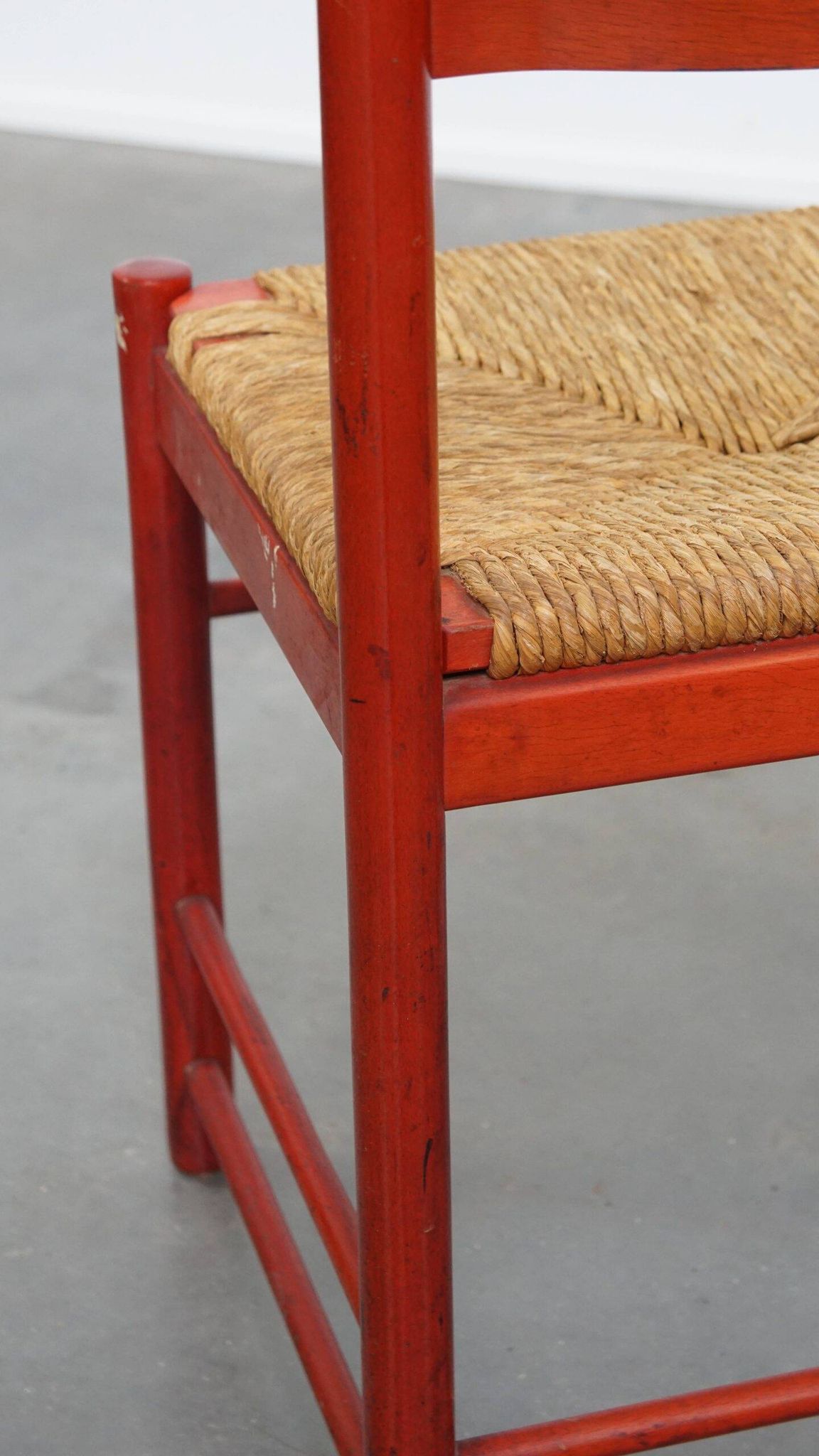 Vintage 1970s red wooden chair with a woven wicker seat