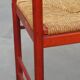 Vintage 1970s red wooden chair with a woven wicker seat