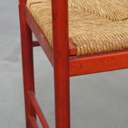 Vintage 1970s red wooden chair with a woven wicker seat