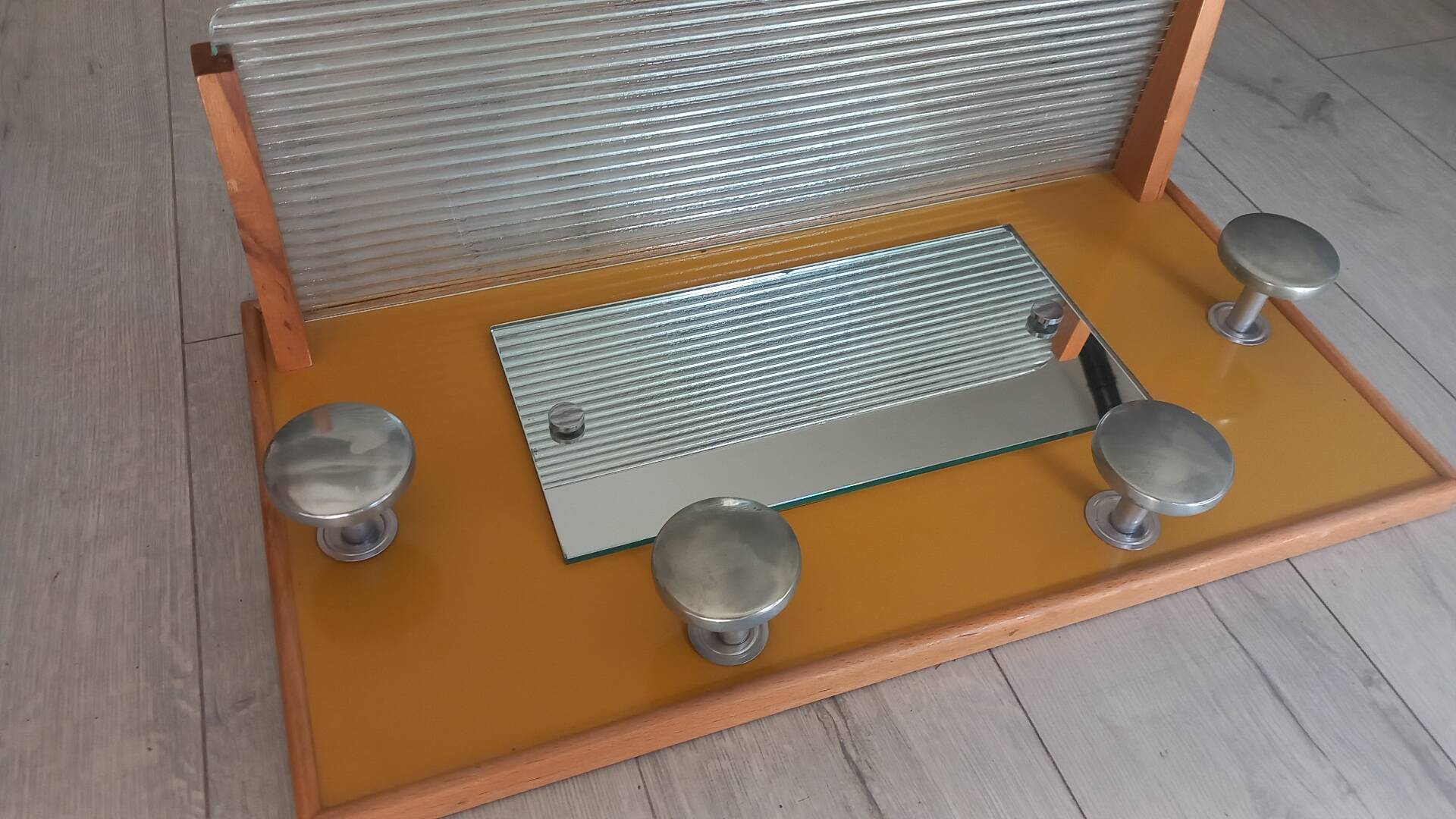1950s coat rack with mirror, metal hooks, and glass shelf.
