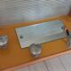 1950s coat rack with mirror, metal hooks, and glass shelf.