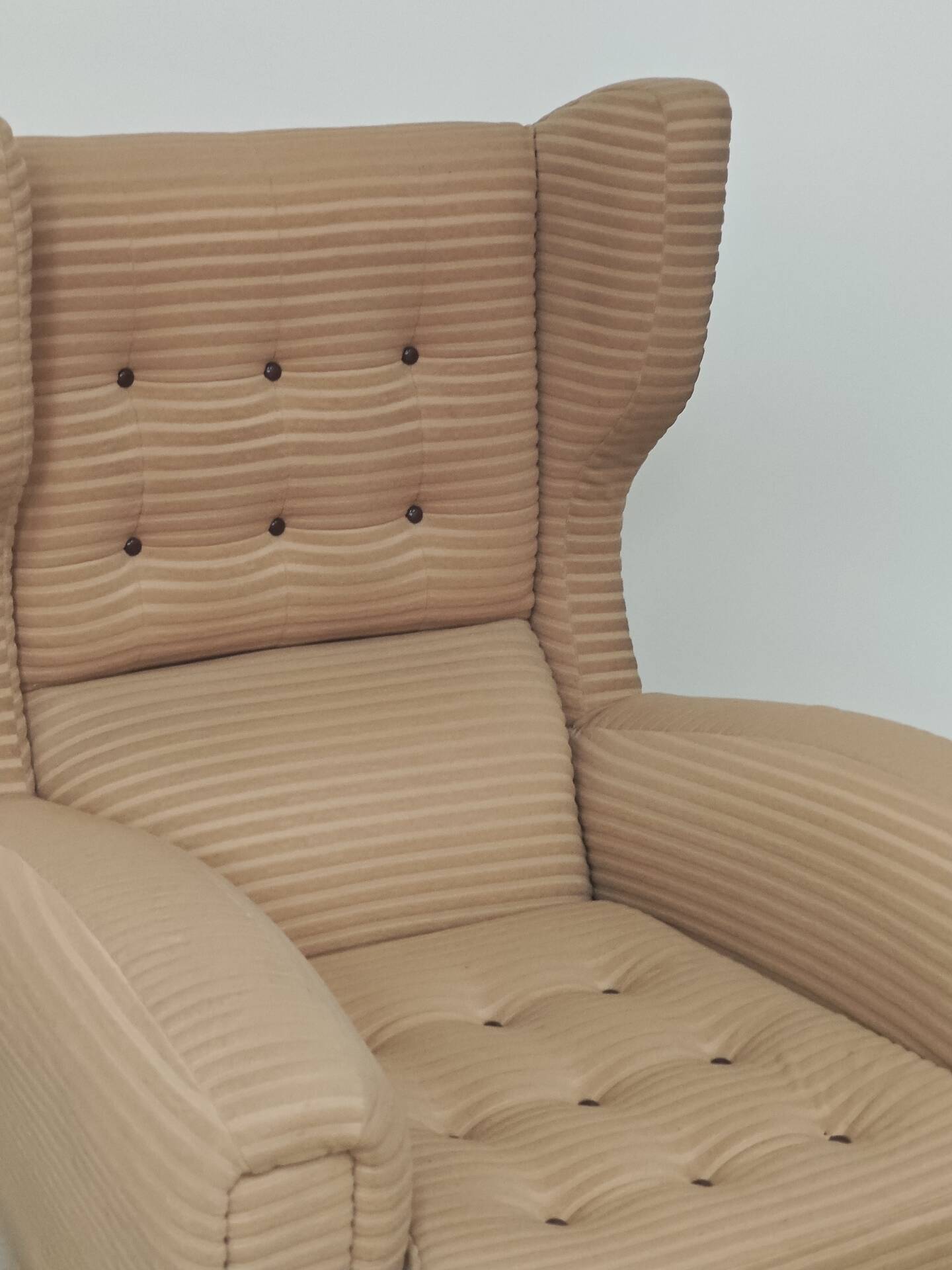 Beige wingback armchair and TVAR footrest, former Czechoslovakia.