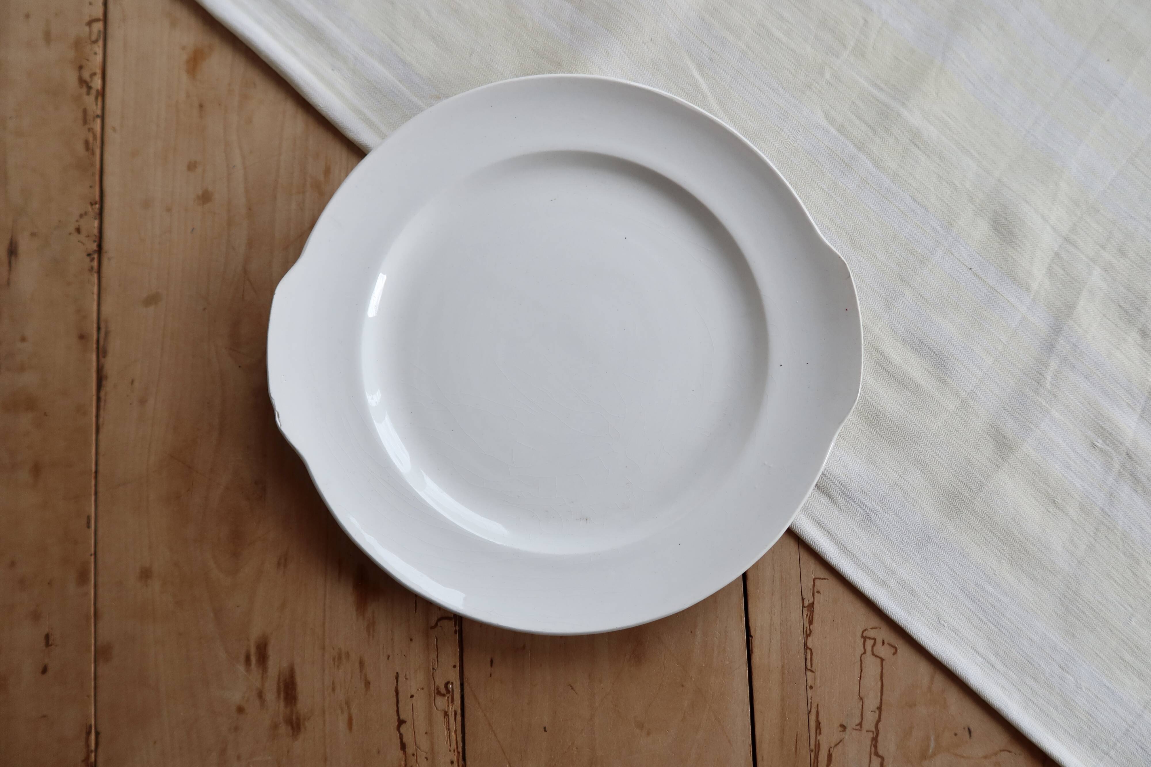 Vintage round white porcelain serving dish with handles.