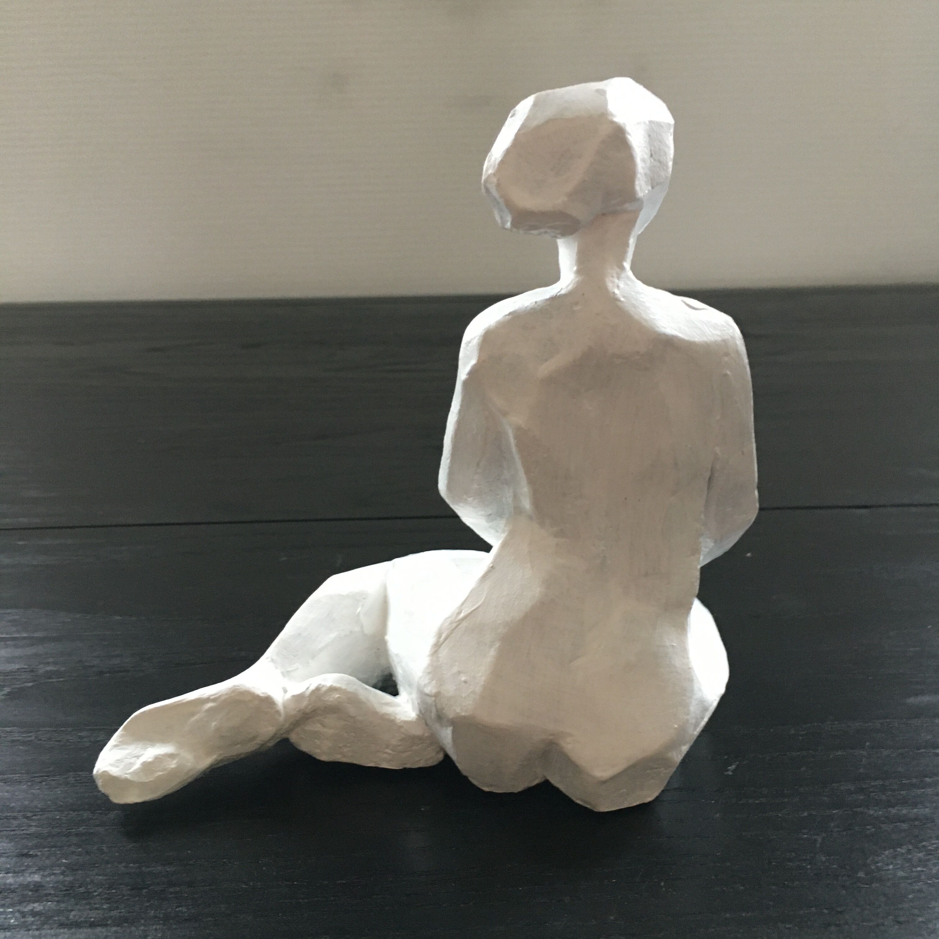 Statuette woman seated in plaster