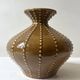Pyriform vase in glazed ochre ceramic and beads.