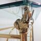 Hollywood Regency brass and glass shelf with elephant heads from the 1970s
